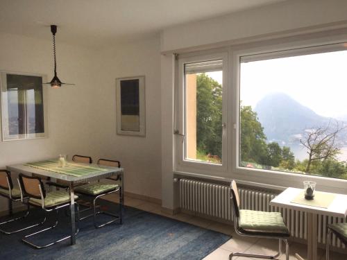 a dining room with a table and chairs and a window at Apartment Aldesago Monte Brè - Utoring-31 by Interhome in Viganello