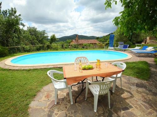 a table and chairs in front of a swimming pool at Holiday Home Ca' di Bacco-1 by Interhome in Nestore