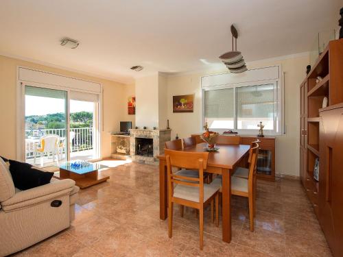 a kitchen and living room with a table and chairs at Holiday Home Juan by Interhome in Segur de Calafell