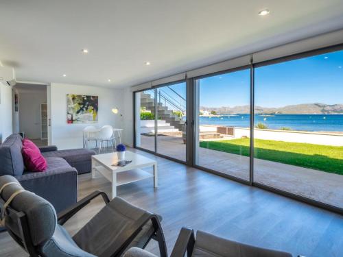 a living room with a large glass door with a view of the ocean at Villa Can Verd by Interhome in Alcudia