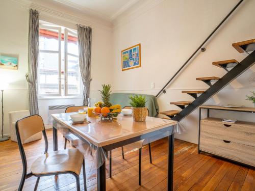 a living room with a dining room table and stairs at Apartment Carlton-1 by Interhome in Biarritz