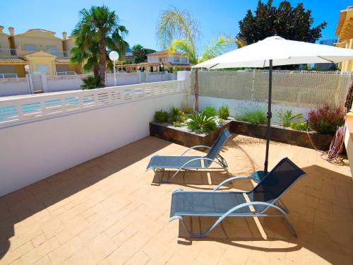 zwei Stühle und ein Regenschirm auf einer Terrasse in der Unterkunft Holiday Home Luz del Sol by Interhome in Calpe