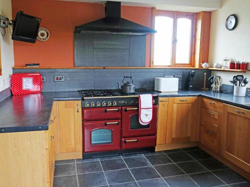 a kitchen with a red stove top oven at Holiday Home Fiskavaig by Interhome in Fiskavaig