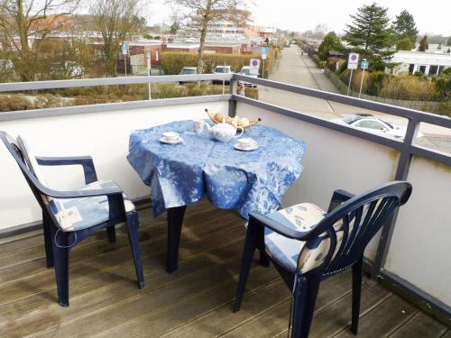 ノルトダイヒにあるApartment Juist by Interhomeのテーブル、バルコニー(椅子2脚、青いテーブルクロス付)