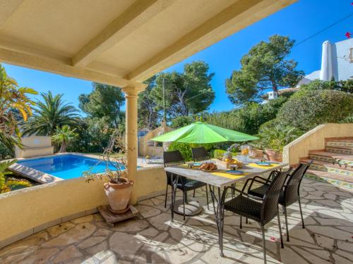 a patio with a table and chairs and a pool at Holiday Home Flamenc by Interhome in Jávea