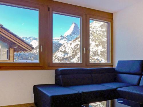 ein Wohnzimmer mit einem Sofa und Bergblick in der Unterkunft Apartment La Prairie by Interhome in Zermatt