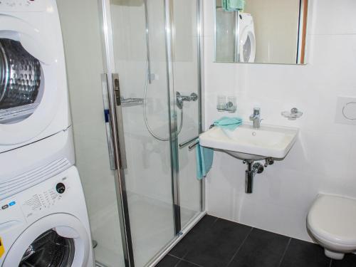 a bathroom with a shower and a sink and a washing machine at Apartment LaVille A-3-4 by Interhome in Locarno