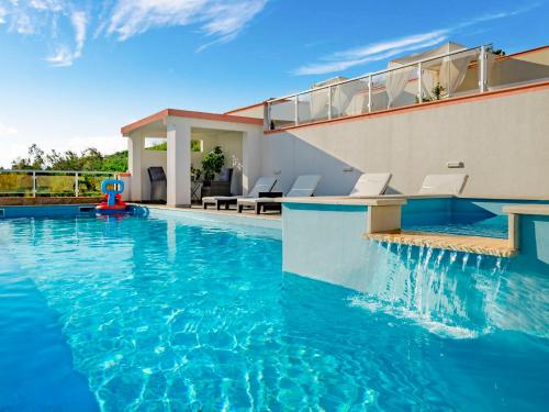 una piscina de agua azul en una casa en Holiday Home Melandura by Interhome, en Dinjiška