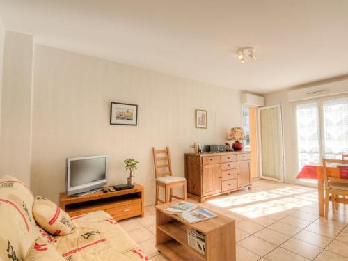 a living room with a couch and a tv at Apartment Maria Callas by Interhome in Labenne