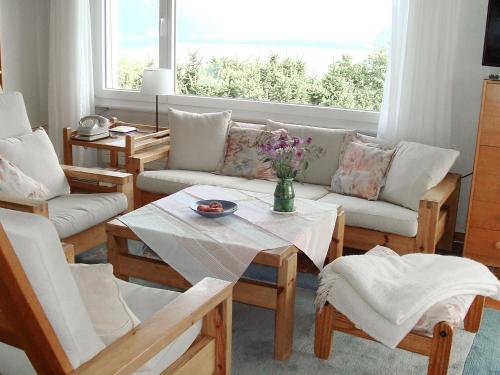 uma sala de estar com um sofá, cadeiras e uma mesa em Holiday Home Noisette by Interhome em Chardonne