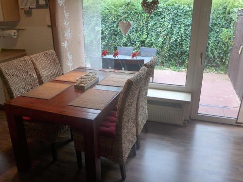 einen Esstisch mit Stühlen und ein Fenster in der Unterkunft Holiday Home Norderney by Interhome in Norddeich