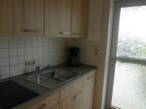 een keuken met een wastafel en een raam bij Apartment Schwalbennest II by Interhome in Norddeich