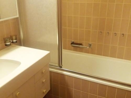 a bathroom with a shower and a tub and a sink at Apartment Apartment 10 by Interhome in Weggis