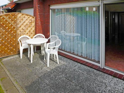 d'une terrasse avec une table et des chaises sur un balcon. dans l'établissement Apartment Teetied by Interhome, à Norddeich