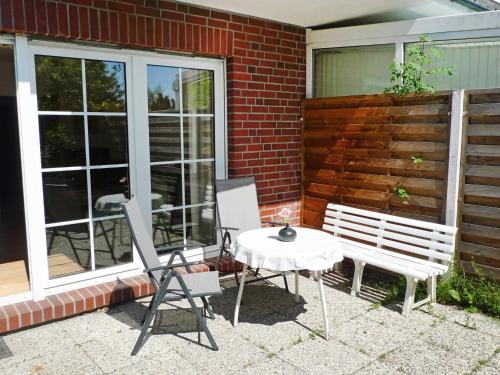 a patio with two chairs and a table and a bench at Apartment Seehund by Interhome in Norddeich