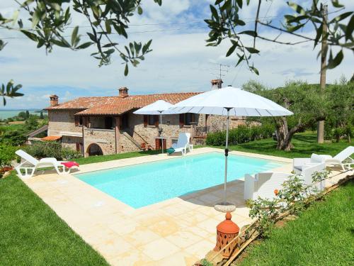 uma piscina com um guarda-sol e uma casa em Holiday Home Trasimeno link by Interhome em San Savino