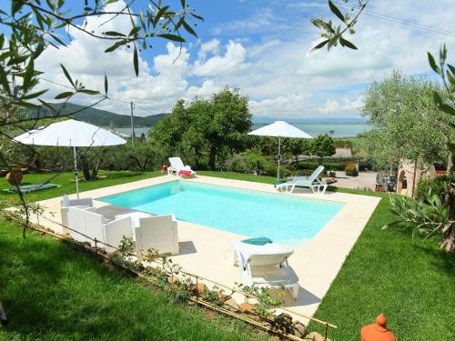 a swimming pool with chairs and umbrellas in a yard at Holiday Home Trasimeno link by Interhome in San Savino