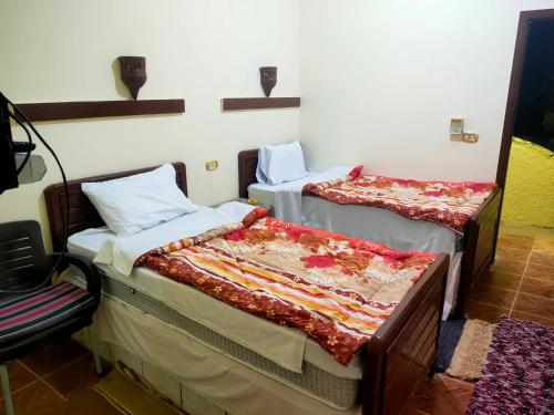 a room with two beds in a room at Ahmed Safari Camp in Bawiti