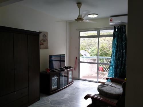 a living room with a couch and a sliding glass door at Family Beach Condo PD at Cocobay Resort Condominium in Port Dickson