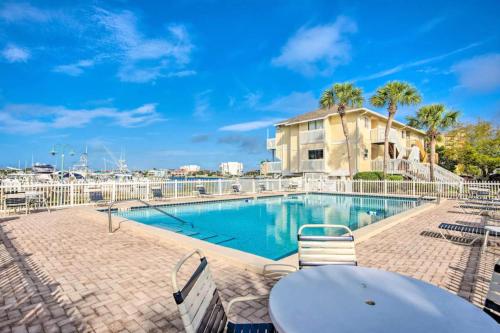 a swimming pool with a table and chairs next to a building at Sandpiper Cove by Panhandle Getaways in Destin