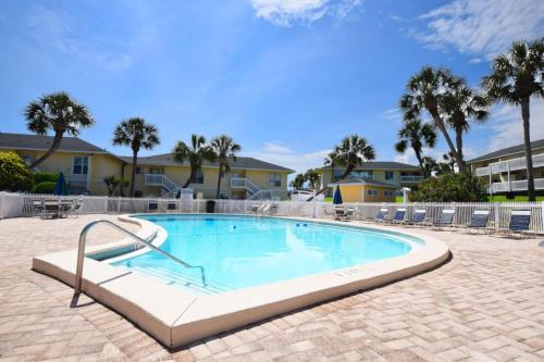 a large swimming pool with chairs and palm trees at Sandpiper Cove by Panhandle Getaways in Destin