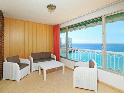 ベニドルムにあるApartment Torre Principado Levante 1st Line-3 by Interhomeの椅子、海の景色を望むバルコニーが備わる客室です。