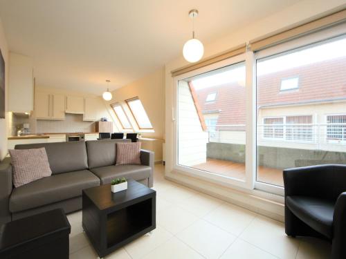 een woonkamer met een bank en een groot raam bij Apartment Residentie Havenhuys-1 by Interhome in Bredene