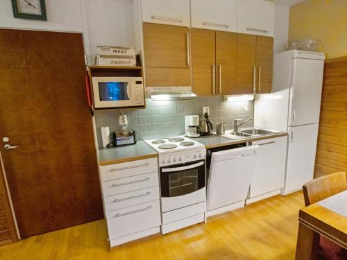 cocina con electrodomésticos blancos y suelo de madera en Holiday Home Ylläs chalets a508 by Interhome, en Ylläs