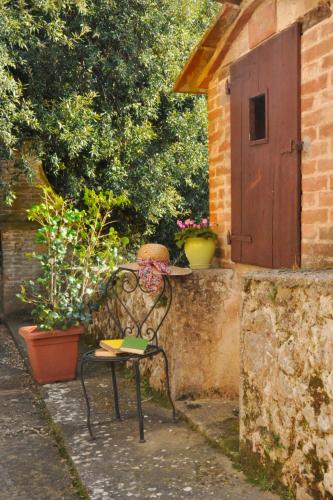 a bench sitting next to a brick wall with a door at Apartment L'Erika by Interhome in Cetinale