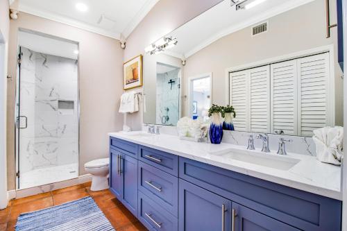 La salle de bains est pourvue d'une coiffeuse bleue et d'une douche. dans l'établissement Palm Isle Village 3208, à Holmes Beach