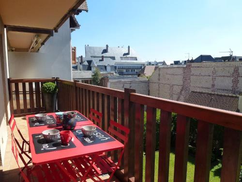 une table et des chaises rouges sur un balcon dans l'établissement Apartment Baccara by Interhome, à Deauville