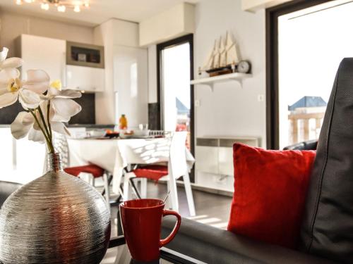 a vase with flowers on a table in a living room at Apartment Baccara by Interhome in Deauville