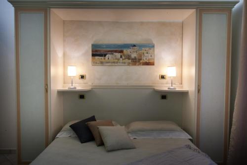 a bedroom with a bed with two lamps on it at Pensione degli Ulivi in Porto SantʼElpidio