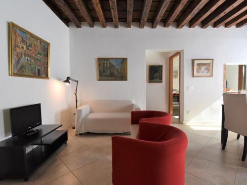 ヴェネツィアにあるApartment Casanas-2 by Interhomeのリビングルーム(赤い椅子、ソファ付)