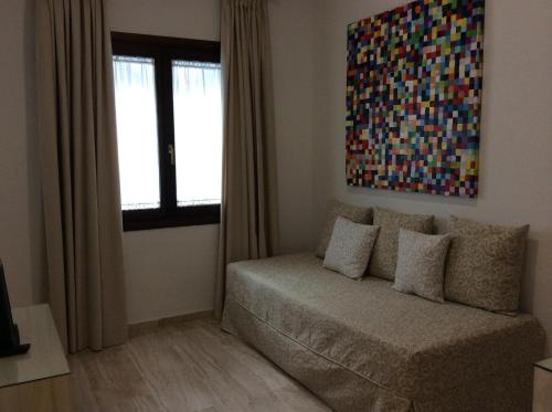 a living room with a couch and a painting on the wall at Hotel Doña Lola Zahara in Zahara de los Atunes