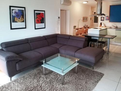 ein Wohnzimmer mit einem braunen Sofa und einem Tisch in der Unterkunft Apartment Residenza Moro by Interhome in Ascona