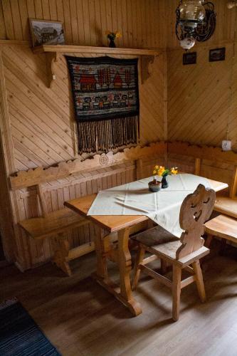 a room with a table and benches in a cabin at Domek i Willa Austryjok in Poronin