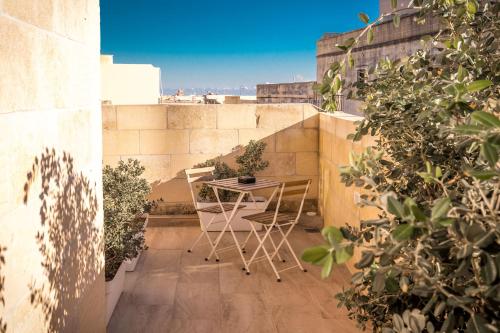 a small balcony with a table and chairs on it at Sweet Life Gozo - Boutique Living in Santa Luċija