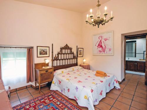 a bedroom with a bed and a chandelier at Holiday Home Can Trullas by Interhome in Viladecaballs