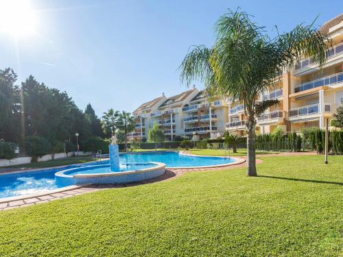 - une piscine avec un palmier et un bâtiment dans l'établissement Apartment Los Sauces by Interhome, à Dénia