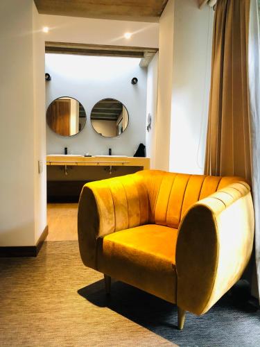 a yellow couch in a room with two mirrors at Alko Hotel Casa Nispero in Cali