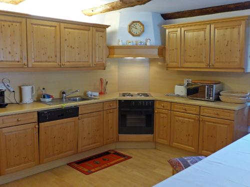 a kitchen with wooden cabinets and a stove top oven at Apartment Chesa Frizzoni by Interhome in Celerina