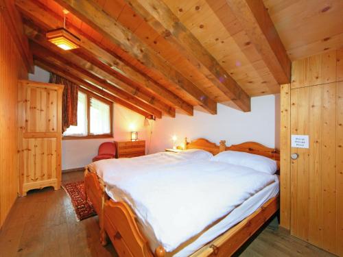 ツェルマットにあるApartment Vitalis by Interhomeの木製天井の客室の大型ベッド1台分です。