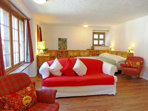ベーヴァにあるStudio Chesa Rossa by Interhomeのリビングルーム(赤と白のソファ、ベッド付)