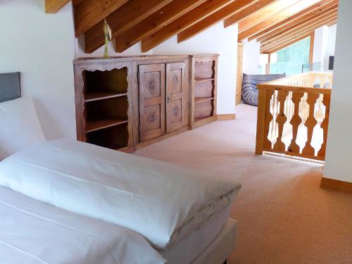 a bedroom with a bed and a wooden dresser at Apartment Chesa Vadret 12 by Interhome in Pontresina