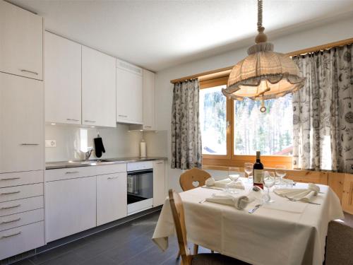 eine Küche mit einem Tisch und einem weißen Tischtuch in der Unterkunft Apartment Chesa Islas by Interhome in Pontresina