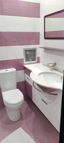 a bathroom with a white toilet and a sink at Apartament Kostov Sliven in Sliven