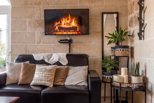 a living room with a couch and a fireplace at Sweet Life Gozo in Santa Luċija