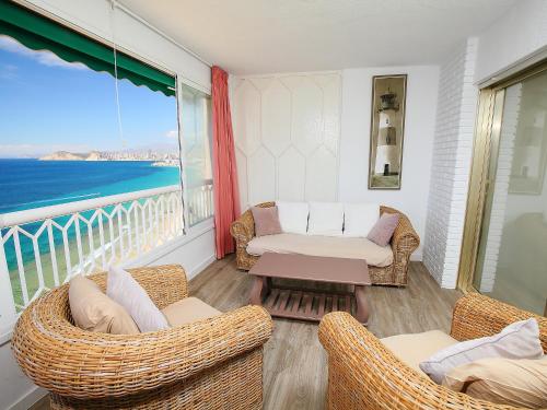 a balcony with chairs and a couch and a table at Apartment Torre Principado by Interhome in Benidorm