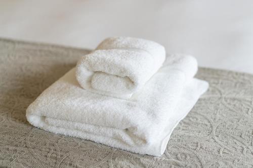 biały ręcznik siedzący na łóżku w obiekcie The Ironmongers Boutique accommodation w mieście Aylsham